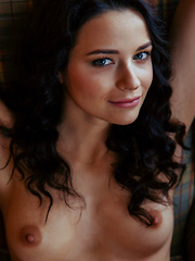 Erotic picture of Ardelia A sensually strips her sexy lingerie on the couch.