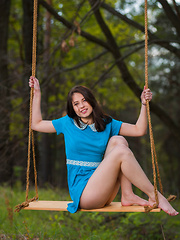 Erotic picture of Hilary C playfully poses outdoors baring her slender body on the swing.