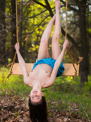 Erotic picture of Hilary C playfully poses outdoors baring her slender body on the swing.