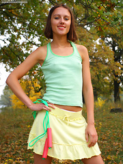 Erotic picture of Slim teen girl takes off green top, yellow skirt and white panties.
