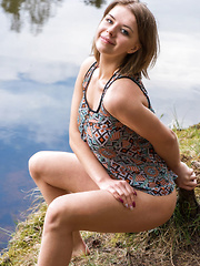 Erotic picture of Yelena strips by the river baring her curvy hips and big tits.