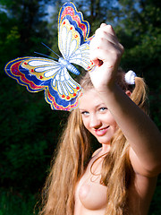 Erotic picture of Perfect long haired busty teen cutie taking off her clothes and catching a big butterfly.