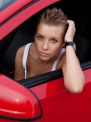 Erotic picture of Fascinating teen girl undressing and showing attractive slim body outdoors near red opel.