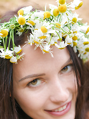 Erotic picture of Adorable busty teen girl posing in only a wreath of daisies on her head in a sand quarry.