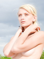Erotic picture of Marvelous blonde hottie posing in the nude with an inflatable ball outdoor on the sand.