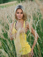 Erotic picture of With a confident, charming allure, Taylor is a stunning sight as she strips her hot yellow dress amidst the tall, verdant grass and tree.