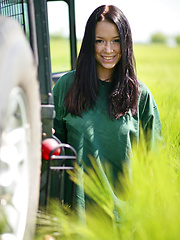 Erotic picture of Gwen playfully strips her green shirt matching the green grassy field and poses naughtily all over the jeep, flaunting her awesome physique and gorgeous breasts.