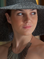Erotic picture of Wearing a broad brimmed hat, a chunky piece of necklace, and a sheer black panty