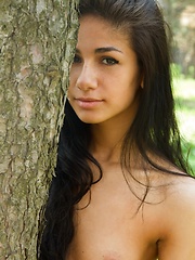 Erotic picture of Fresh and exotic beautiful Malina relaxes amongst the lush grass and trees.