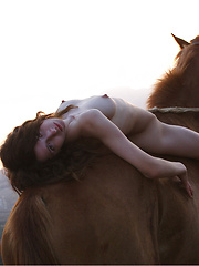 Erotic picture of Riding in a strong horse is this brunette with kinky hair and alabaster skin.
