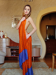 Erotic picture of With just her orange flowing shawl to   cover her slender luscious body, Katie   makes a tempting presence in the living   room, posing without any hint of   inhibition.