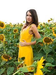 Erotic picture of Semmi strips her yellow sexy dress and   dazzles us with her voluptuous body   with super smooth and fair skin, puffy large breasts, and her alluring blue eyes in the sunflower field.