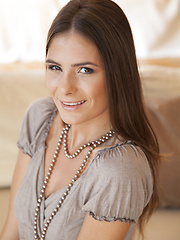 Erotic picture of Csilla smiles sweetly as she strips off her clothes on top of the sofa