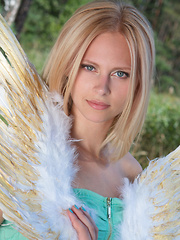 Erotic picture of Amazing blonde teen babe gets naked on the lap of nature and tries to mimic some angelic beauty with her poses.