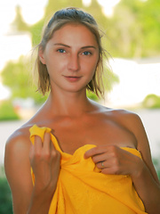 Erotic picture of Lovely teen beauty showing perky tits and playful pussy under sexy yellow dress on public.