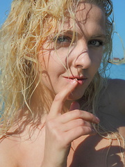 Erotic picture of This petite blonde takes her hot beach outfit off piece by piece and you see more of her juiciness.